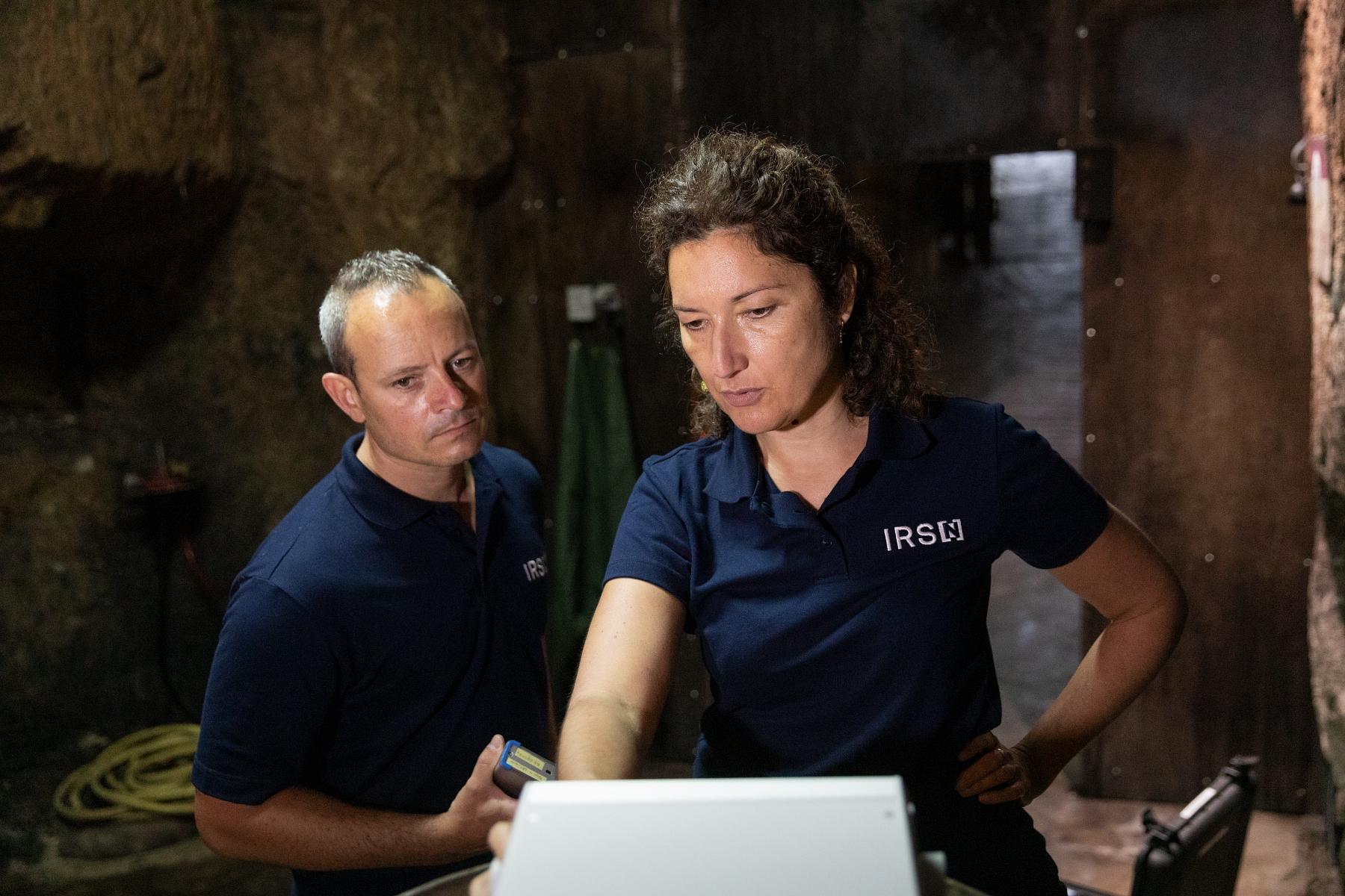  Légende : Dans la cave du Domaine Fouet, Caroline Vignaud et Laurent Destacamp, tous deux ingénieurs au Bureau d’étude et d’expertise du radon (BERAD) de l’IRSN, manipulent un RPM 2200 (SARAD), un moniteur de descendants du radon et thoron